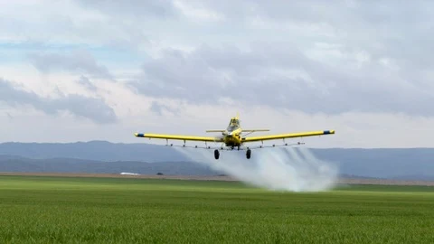 Avión agrícola de Livio S.A. realizando una aplicación aérea sobre un lote verde